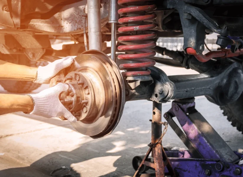 Technician replacing front struts on diesel truck in Edmonton