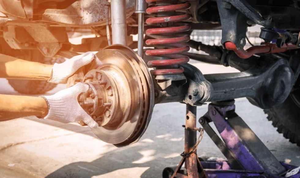 Suspension system parts laid Technician replacing front struts on diesel truck in Edmonton
