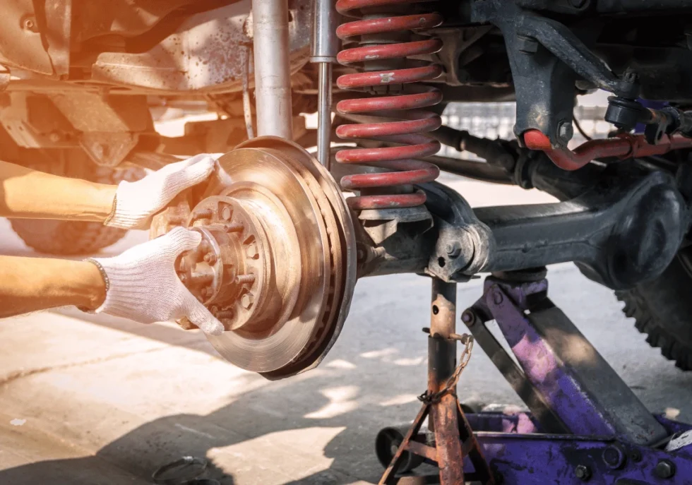 Technician replacing front struts on diesel truck in Edmonton